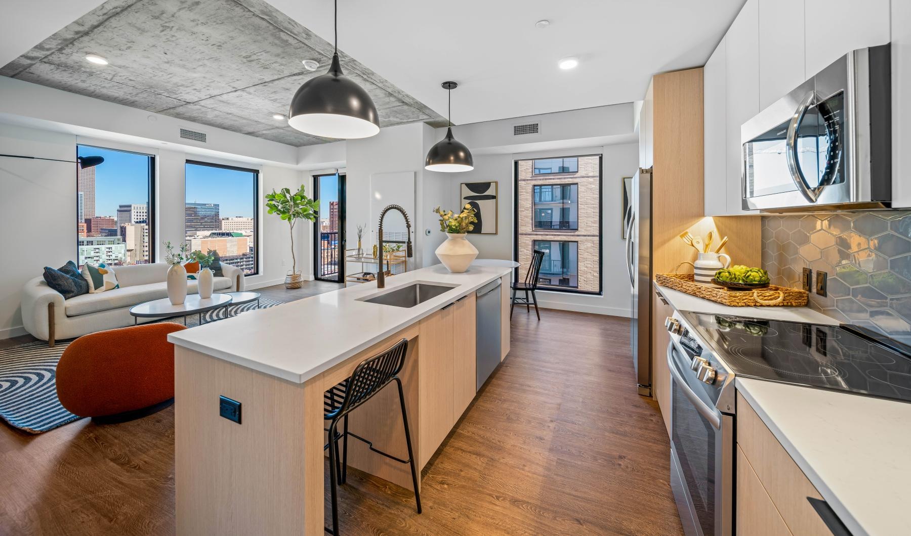 a kitchen with a large island stove and living space in the background